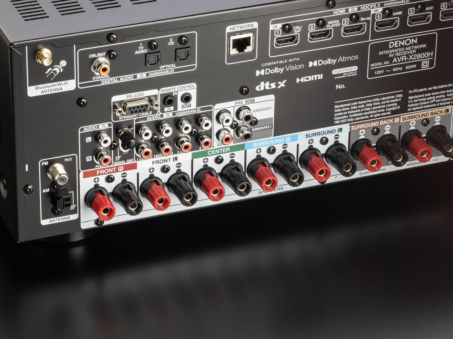 Podrobna slika Denon AVR-X2800H DAB sprejemnika, ki prikazuje zadnjo ploščo z zvočniškimi in video vhodi in izhodi.