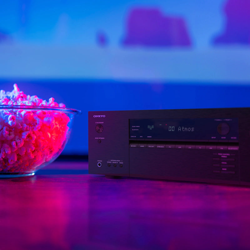 Onkyo TX-SR3100 v domačem kinu, povezan s televizorjem in zvočniki za prostorski zvok.