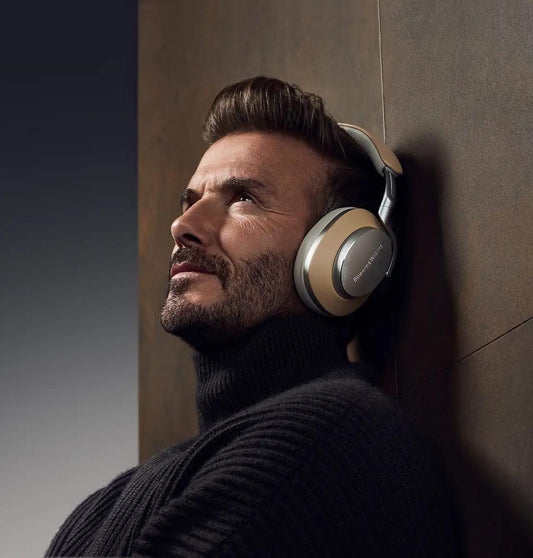 Bowers & Wilkins PX8 Tan: Brezžične naglavne slušalke z ANC odpravljanjem hrupa in elegantno  barvo. Na sliki jih nosi David Beckham.