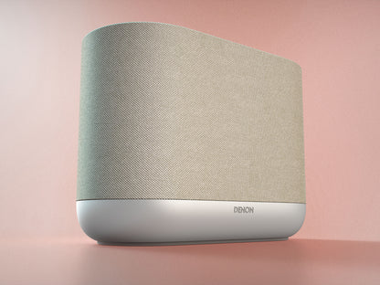 Denon Home 400 v elegantni beli barvi (Stone), ki se minimalistično zlije s svetlo opremljenimi prostori in modernim interierjem.