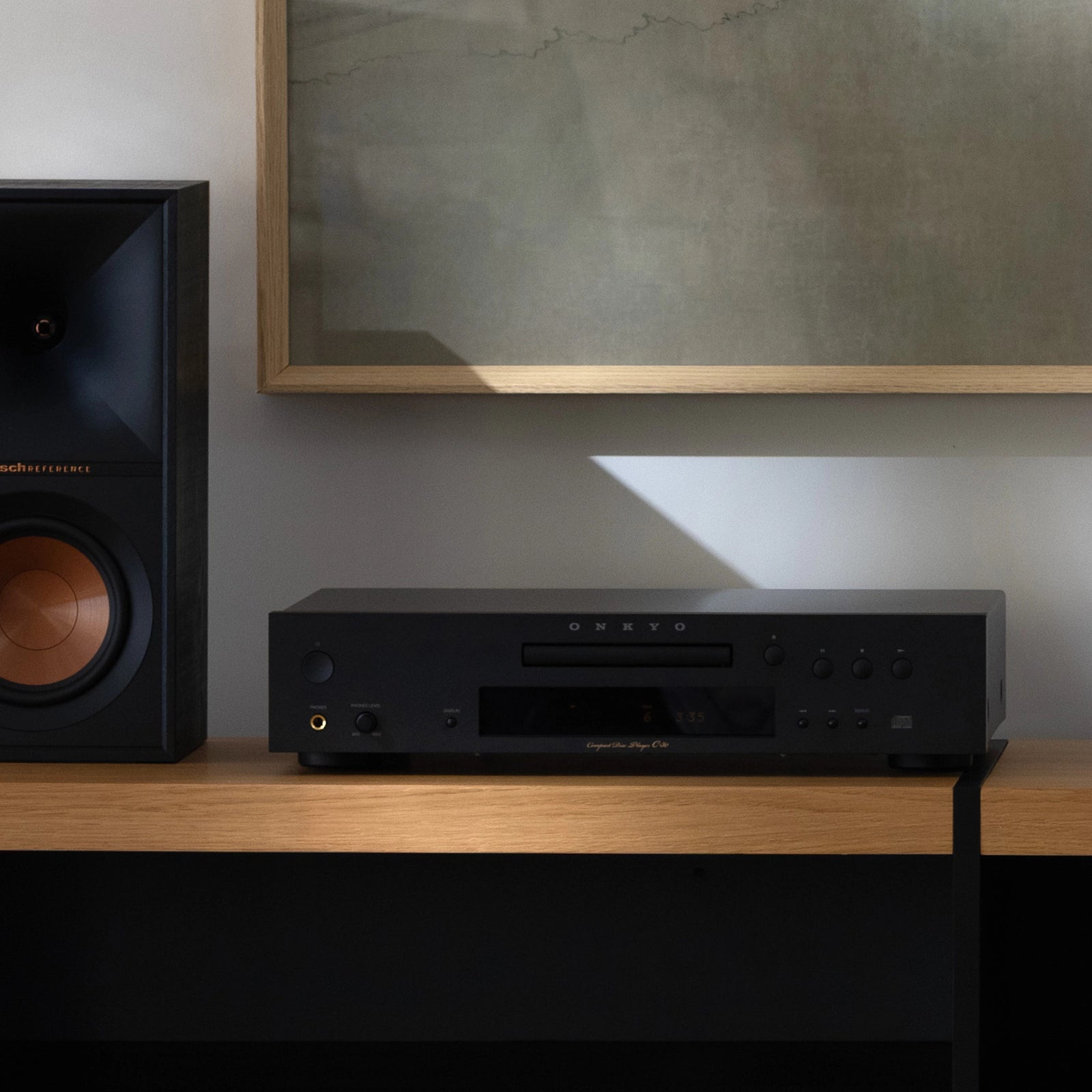 Onkyo Icon C-30 CD predvajalnik v moderni dnevni sobi postavljen na Hi-Fi omarici poleg gramofona in Klipsch zvočnika.