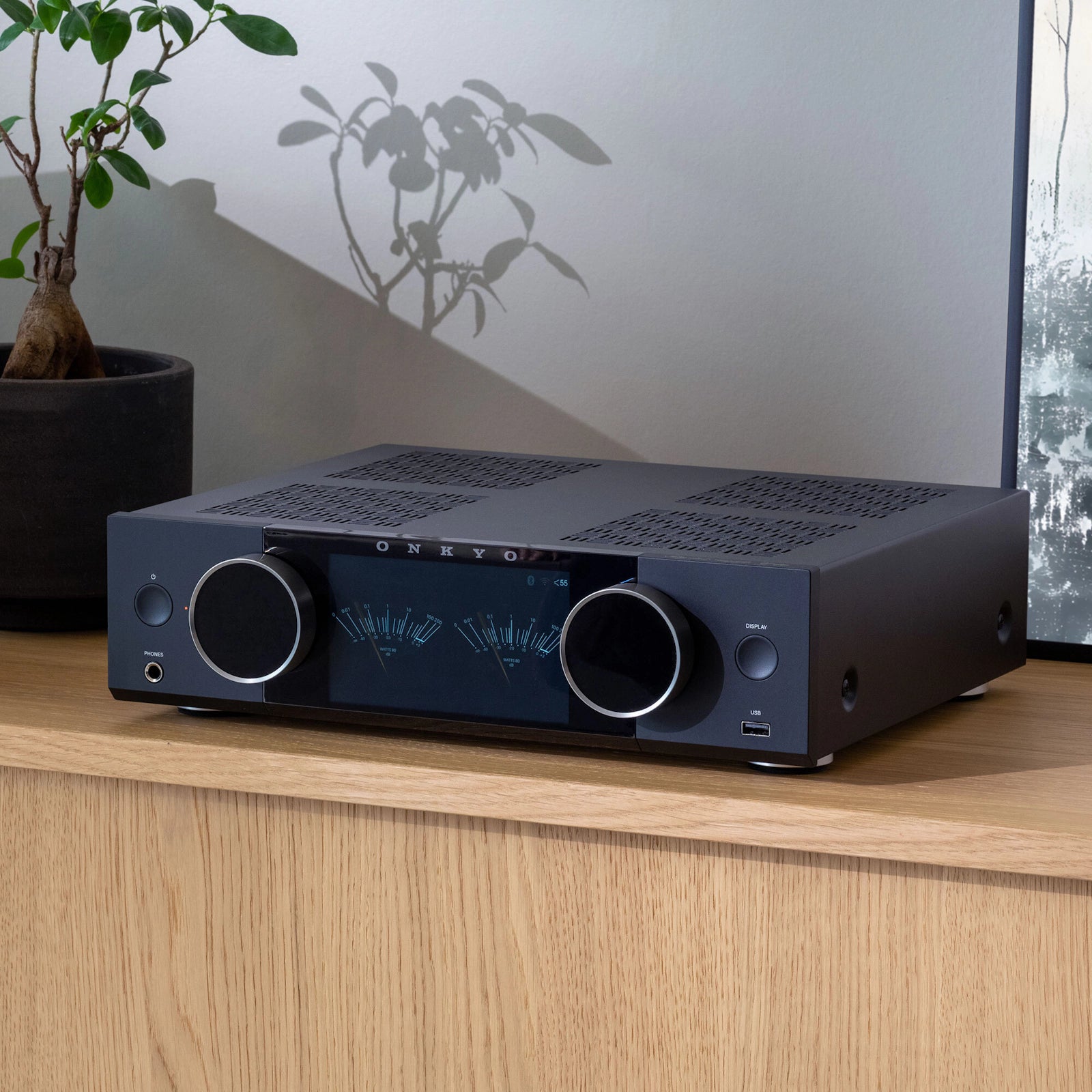 Onkyo Muse Y-40 mrežni ojačevalnik na leseni polici v moderni dnevni sobi.