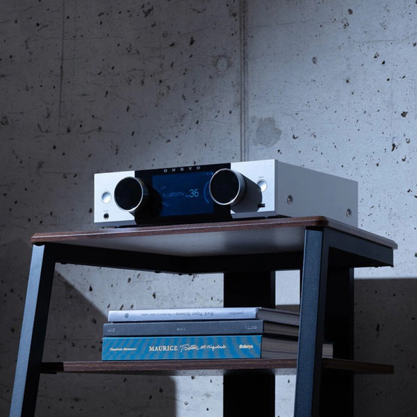 Onkyo Muse Y-40 z osvetljenim LCD zaslonom in retro VU metri v minimalistično opremljenem prostoru.